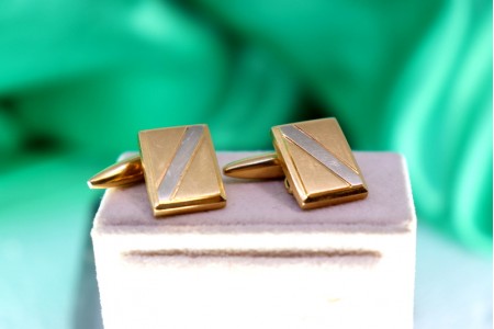 Botões de punho em ouro bicolor retangulares com banda em diagonal.